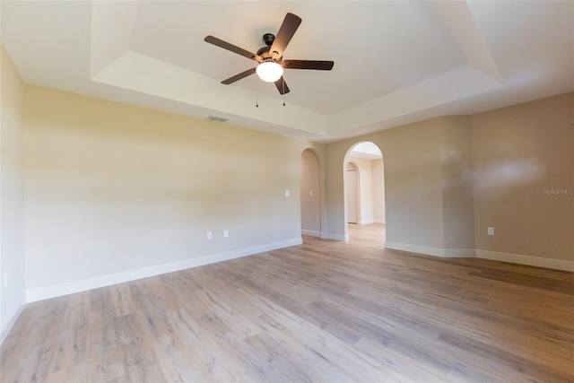 45 Pecan Course Loop, Ocala, FL 34472 - unfurnished room featuring a tray ceiling, ceiling fan, arched walkways, and light wood-style flooring