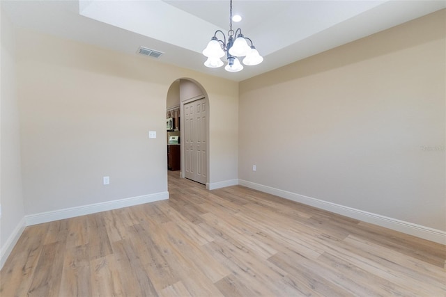45 Pecan Course Loop, Ocala, FL 34472 - unfurnished room with arched walkways, light wood-style floors, and a chandelier