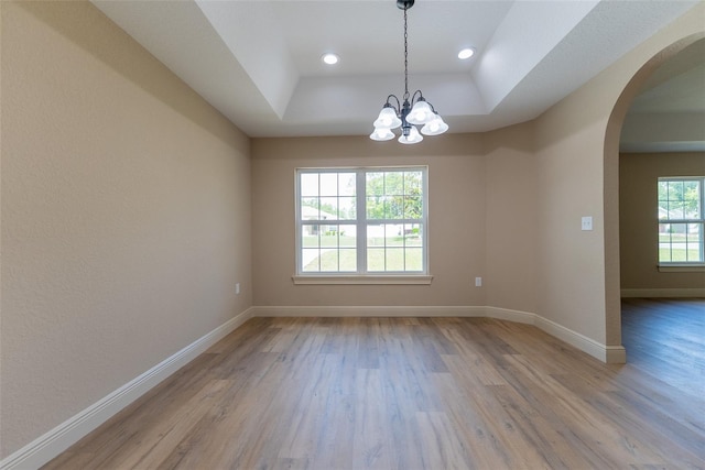 45 Pecan Course Loop, Ocala, FL 34472 - spare room featuring arched walkways, light wood-style floors, a tray ceiling, a chandelier, and recessed lighting
