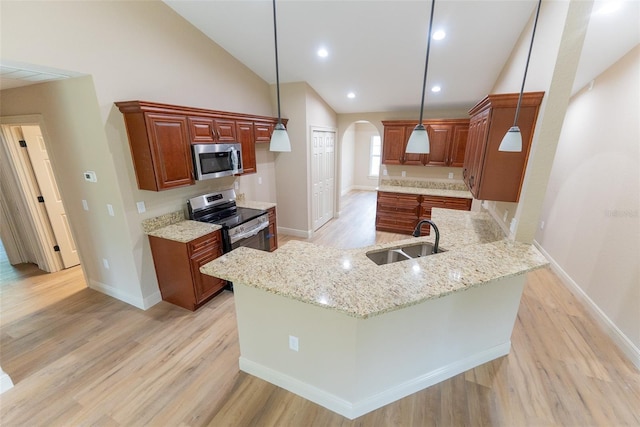 45 Pecan Course Loop, Ocala, FL 34472 - kitchen featuring appliances with stainless steel finishes, vaulted ceiling, arched walkways, light wood-style floors, and a peninsula