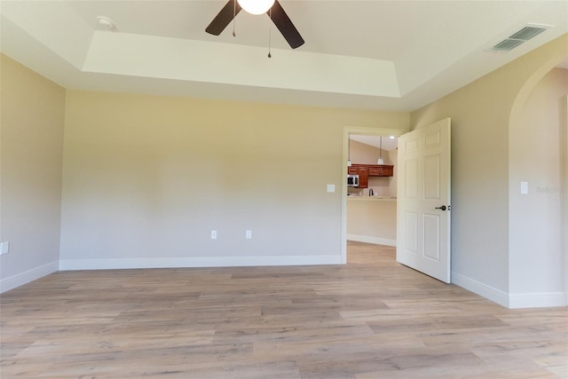 45 Pecan Course Loop, Ocala, FL 34472 - spare room featuring arched walkways, a raised ceiling, light wood-style floors, and a ceiling fan