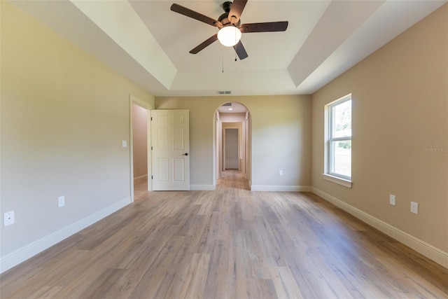 45 Pecan Course Loop, Ocala, FL 34472 - unfurnished room with a tray ceiling, arched walkways, a ceiling fan, and light wood finished floors
