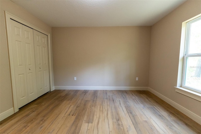 45 Pecan Course Loop, Ocala, FL 34472 - unfurnished bedroom with light wood-type flooring, multiple windows, and a closet