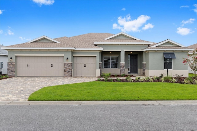 10880 SW 101st Loop, Ocala, FL 34481 - view of front of property featuring a front yard, a garage, decorative driveway, stone siding, and stucco siding