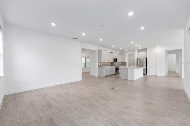 10880 SW 101st Loop, Ocala, FL 34481 - unfurnished living room with light wood finished floors and recessed lighting