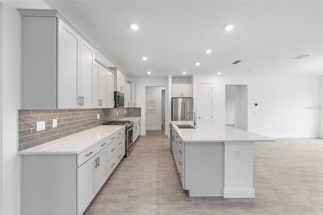 10880 SW 101st Loop, Ocala, FL 34481 - kitchen featuring appliances with stainless steel finishes, tasteful backsplash, recessed lighting, light wood-style flooring, and a center island with sink