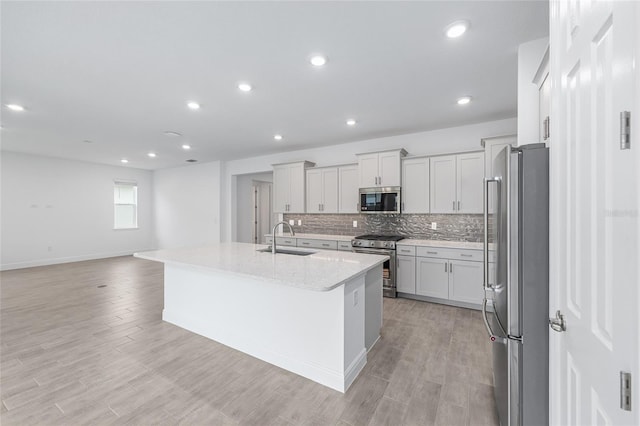 10880 SW 101st Loop, Ocala, FL 34481 - kitchen with stainless steel appliances, tasteful backsplash, an island with sink, light wood-type flooring, and recessed lighting