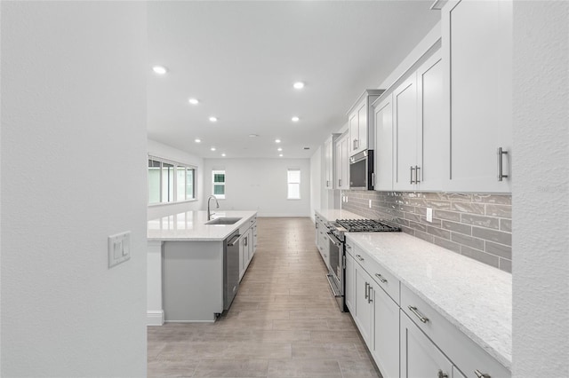 10880 SW 101st Loop, Ocala, FL 34481 - kitchen featuring appliances with stainless steel finishes, tasteful backsplash, recessed lighting, light wood-type flooring, and a center island with sink