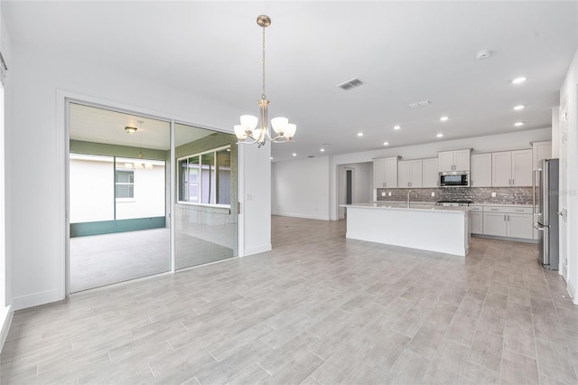 10880 SW 101st Loop, Ocala, FL 34481 - kitchen with stainless steel appliances, a chandelier, open floor plan, recessed lighting, and decorative backsplash