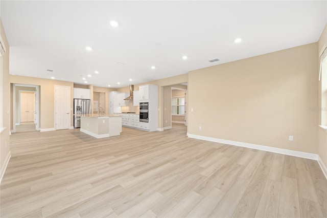 10833 SW 101st Loop, Ocala, FL 34481 - unfurnished living room with light wood-type flooring and recessed lighting