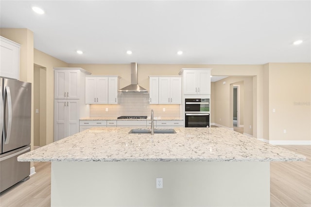 10833 SW 101st Loop, Ocala, FL 34481 - kitchen featuring stainless steel appliances, wall chimney exhaust hood, light wood-style flooring, tasteful backsplash, and white cabinetry