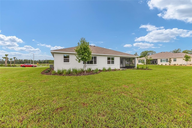 10833 SW 101st Loop, Ocala, FL 34481 - back of property with a lawn, stucco siding, and a sunroom