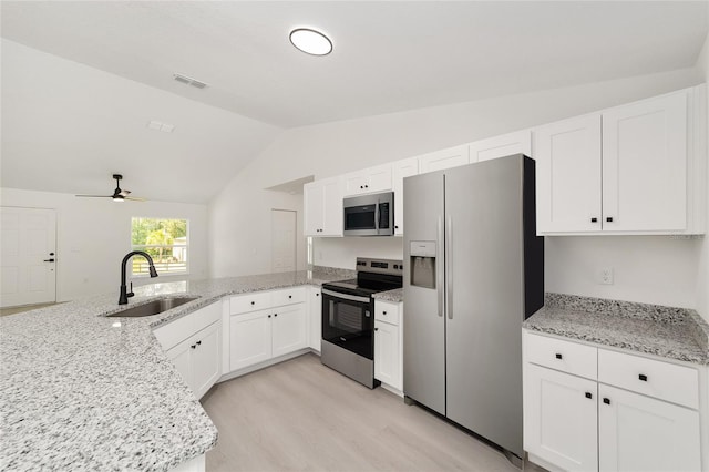 1581 SW Paradise Heights Rd, Dunnellon, FL 34431 - kitchen featuring stainless steel appliances, lofted ceiling, white cabinetry, and a peninsula
