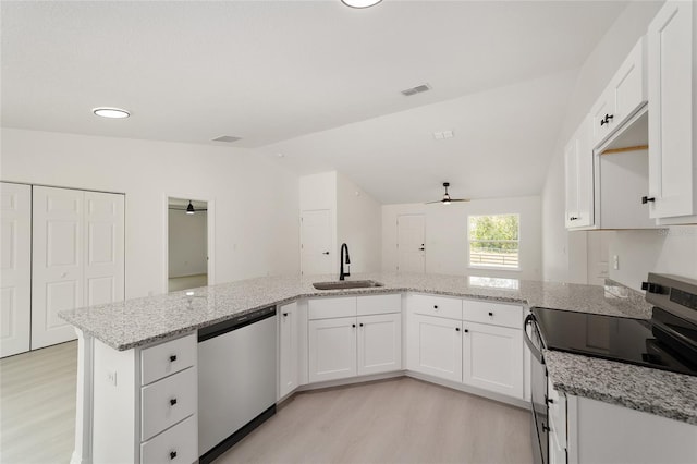 1581 SW Paradise Heights Rd, Dunnellon, FL 34431 - kitchen with stainless steel appliances, a ceiling fan, light wood finished floors, lofted ceiling, and white cabinetry