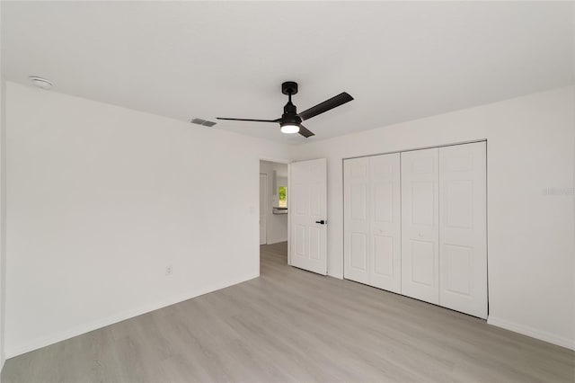 1581 SW Paradise Heights Rd, Dunnellon, FL 34431 - unfurnished bedroom with light wood-style flooring, a closet, and ceiling fan