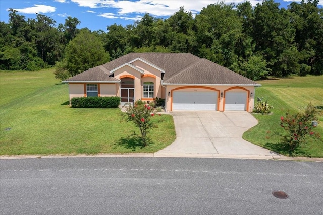 19583 SW 77th Loop, Dunnellon, FL 34432 - view of front facade featuring driveway, stucco siding, an attached garage, and a front lawn