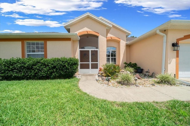 19583 SW 77th Loop, Dunnellon, FL 34432 - entrance to property featuring stucco siding, a yard, and a garage
