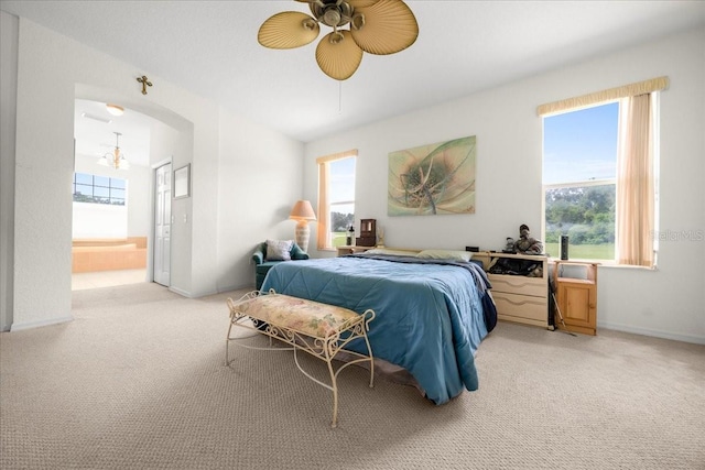19583 SW 77th Loop, Dunnellon, FL 34432 - bedroom with light carpet, ensuite bath, arched walkways, and ceiling fan