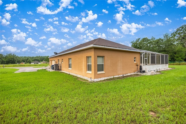 2587 W Angola Dr, Beverly Hills, FL 34465 - view of side of home with a yard, stucco siding, and a sunroom