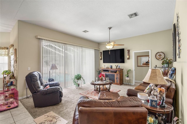 2587 W Angola Dr, Beverly Hills, FL 34465 - living area with ceiling fan, tile patterned floors, carpet flooring, a textured ceiling, and a fireplace