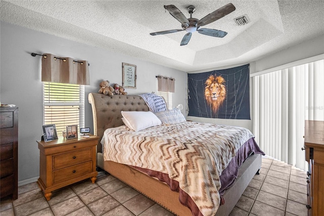 2685 W Apricot Dr, Beverly Hills, FL 34465 - bedroom featuring a tray ceiling, a textured ceiling, ceiling fan, and tile patterned floors