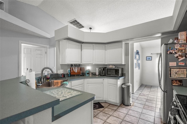 2685 W Apricot Dr, Beverly Hills, FL 34465 - kitchen featuring white cabinetry, a peninsula, vaulted ceiling, dark countertops, and a textured ceiling