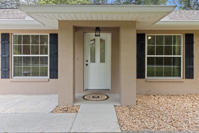 2105 E Dearborn Dr, Hernando, FL 34442 - view of exterior entry featuring stucco siding and a shingled roof