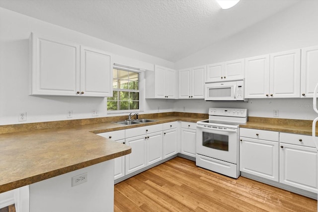 2105 E Dearborn Dr, Hernando, FL 34442 - kitchen featuring white appliances, a peninsula, a textured ceiling, white cabinets, and vaulted ceiling