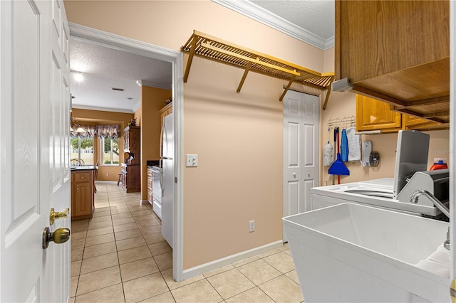 5543 NW 25th Loop, Ocala, FL 34482 - washroom featuring ornamental molding, a textured ceiling, light tile patterned floors, cabinet space, and washer and clothes dryer