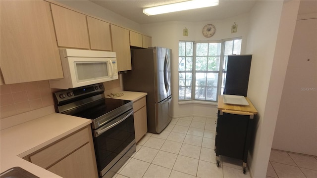 6421 Remus Dr, New Port Richey, FL 34653 - kitchen featuring appliances with stainless steel finishes, light countertops, light tile patterned floors, and light brown cabinets