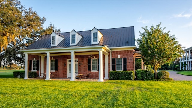 17800 SE 237th Ct, Umatilla, FL 32784 - cape cod home featuring brick siding, a front lawn, a metal roof, and a standing seam roof