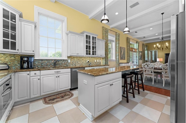 17800 SE 237th Ct, Umatilla, FL 32784 - kitchen with stainless steel appliances, a chandelier, light flooring, beamed ceiling, and healthy amount of natural light