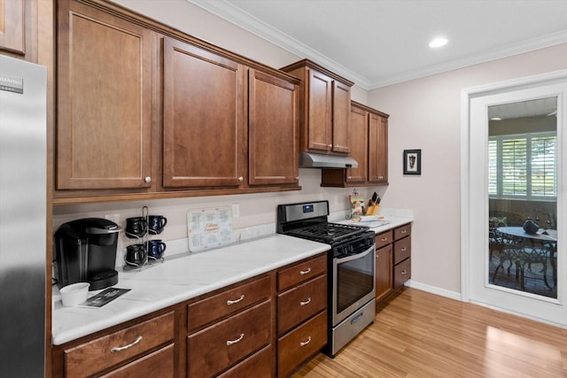 9251 SW 94th Loop, Ocala, FL 34481 - kitchen with appliances with stainless steel finishes, light wood-style floors, light countertops, ornamental molding, and under cabinet range hood