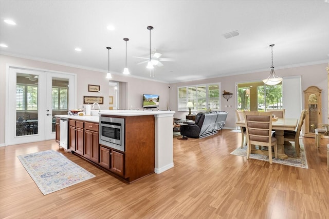 9251 SW 94th Loop, Ocala, FL 34481 - kitchen with ceiling fan, open floor plan, healthy amount of natural light, light wood finished floors, and crown molding