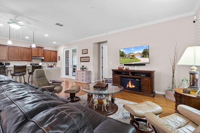 9251 SW 94th Loop, Ocala, FL 34481 - living area with light wood finished floors, crown molding, a ceiling fan, a glass covered fireplace, and recessed lighting