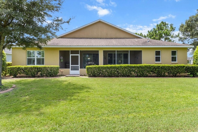 9251 SW 94th Loop, Ocala, FL 34481 - back of house with a sunroom, a yard, stucco siding, and roof with shingles
