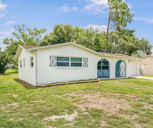 231 S Barbour St, Beverly Hills, FL 34465 - view of front of house featuring stucco siding, a front yard, a garage, and driveway