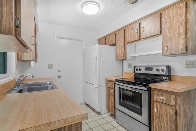 231 S Barbour St, Beverly Hills, FL 34465 - kitchen featuring stainless steel electric stove, freestanding refrigerator, light countertops, light tile patterned flooring, and a textured ceiling