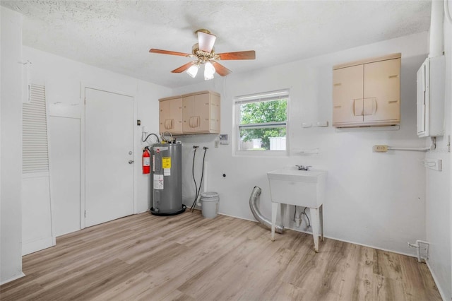 231 S Barbour St, Beverly Hills, FL 34465 - washroom with cabinet space, water heater, light wood finished floors, a ceiling fan, and a textured ceiling