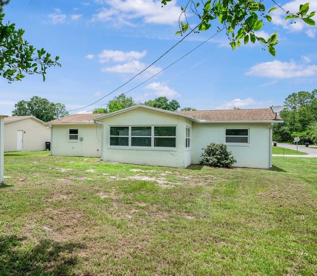231 S Barbour St, Beverly Hills, FL 34465 - back of property featuring stucco siding and a yard