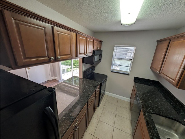 2564 SE 15th Ave Unit G, Ocala, FL 34471 - kitchen featuring black appliances, plenty of natural light, a textured ceiling, dark stone countertops, and light tile patterned floors