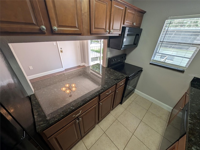 2564 SE 15th Ave Unit G, Ocala, FL 34471 - kitchen featuring black appliances, dark stone countertops, and light tile patterned flooring
