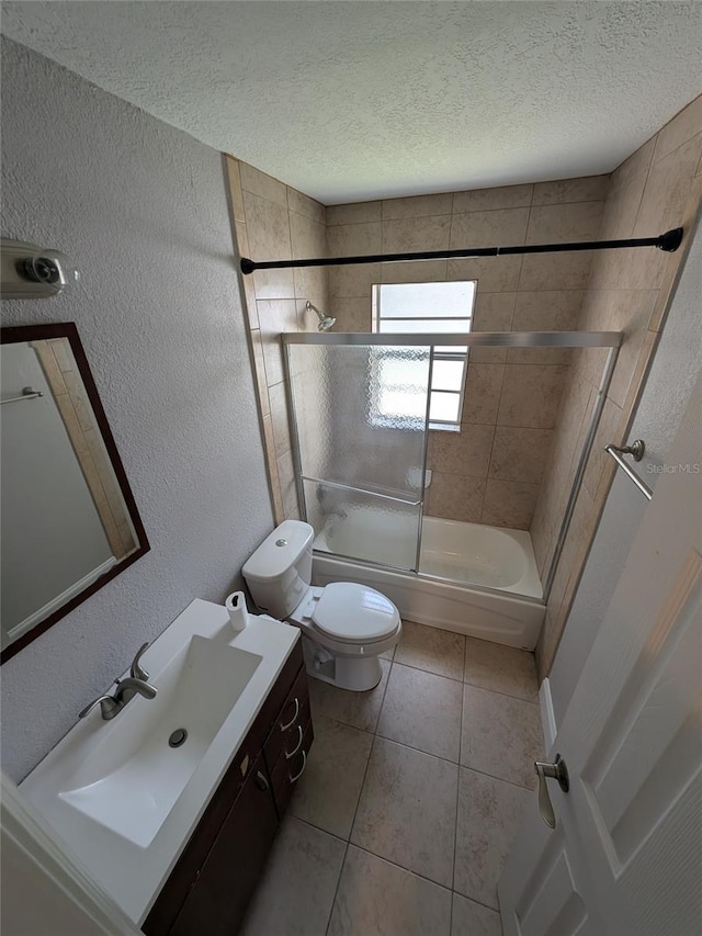 2564 SE 15th Ave Unit G, Ocala, FL 34471 - full bathroom with vanity, shower / bath combination with glass door, a textured ceiling, a textured wall, and tile patterned floors