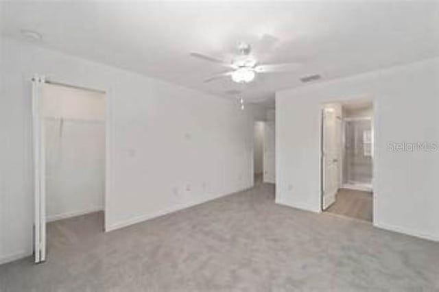 3409 SW 34th Ave Circle Unit 5, Ocala, FL 34474 - unfurnished bedroom with a spacious closet, carpet flooring, connected bathroom, and ceiling fan
