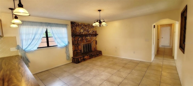 406WRIGHTST Wright St, Inverness, FL 34452 - unfurnished living room featuring arched walkways, light tile patterned floors, a chandelier, a fireplace, and a textured ceiling