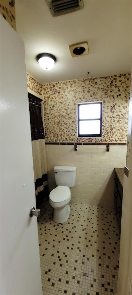 406WRIGHTST Wright St, Inverness, FL 34452 - bathroom with tile walls, wainscoting, tile patterned flooring, a shower with curtain, and wallpapered walls