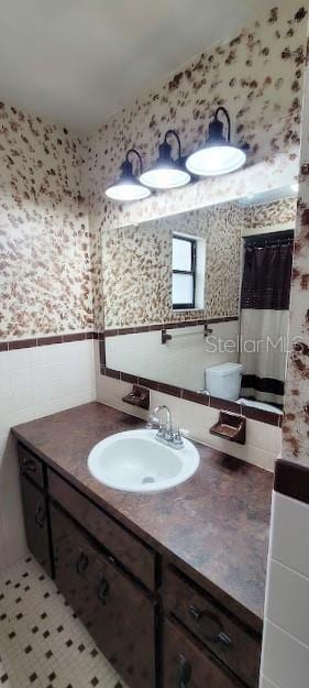 406WRIGHTST Wright St, Inverness, FL 34452 - bathroom featuring tile walls, vanity, wallpapered walls, and wainscoting