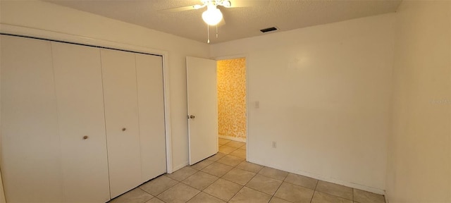 406WRIGHTST Wright St, Inverness, FL 34452 - unfurnished bedroom featuring a closet, light tile patterned flooring, a textured ceiling, and a ceiling fan