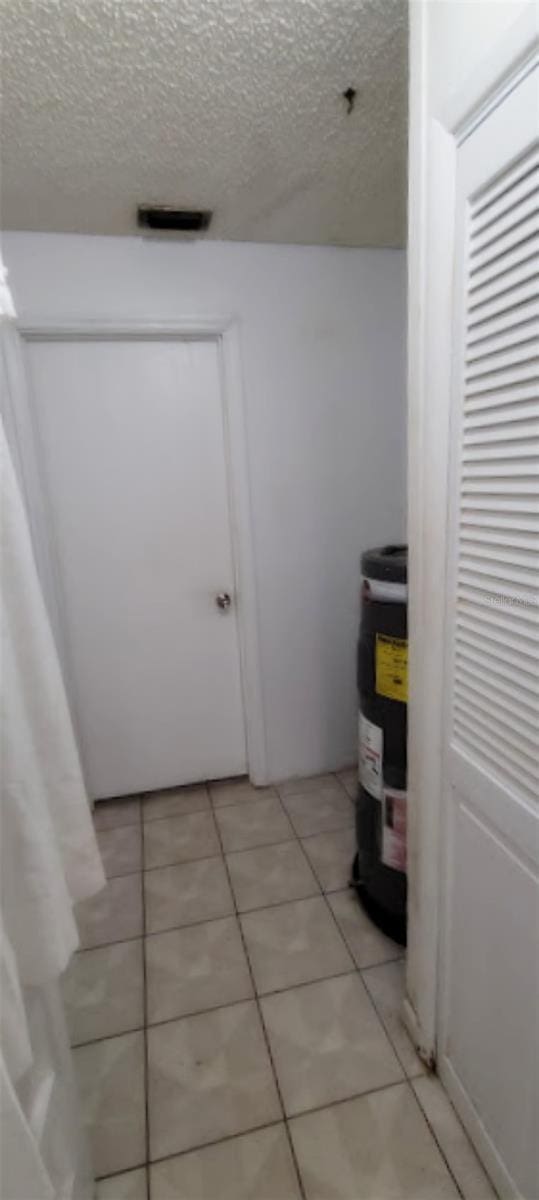 406WRIGHTST Wright St, Inverness, FL 34452 - bathroom featuring a textured ceiling, tile patterned flooring, and electric water heater