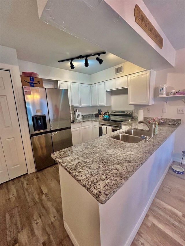 2214 NE 45th Ave Unit 3, Ocala, FL 34470 - kitchen with a peninsula, stainless steel appliances, white cabinets, and wood finished floors